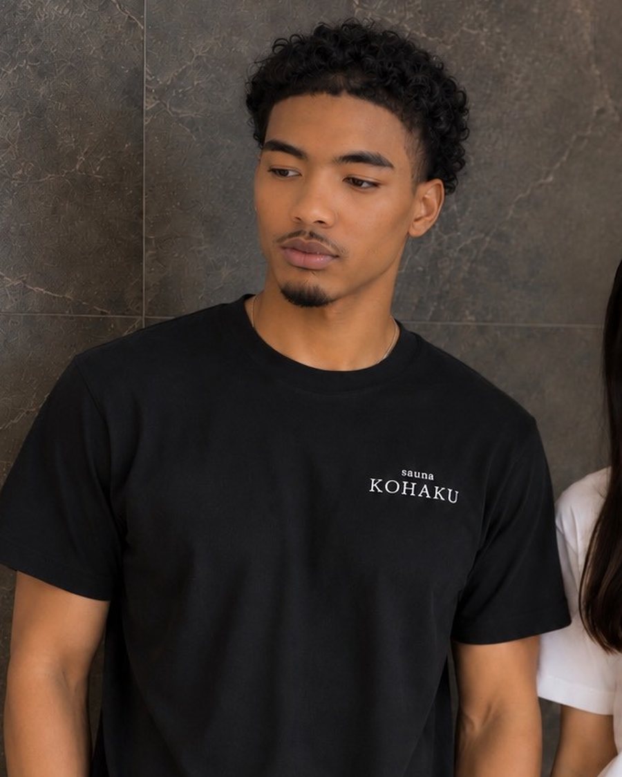 黒のTシャツを着用したモデル。胸元に sauna KOHAKU のロゴ
